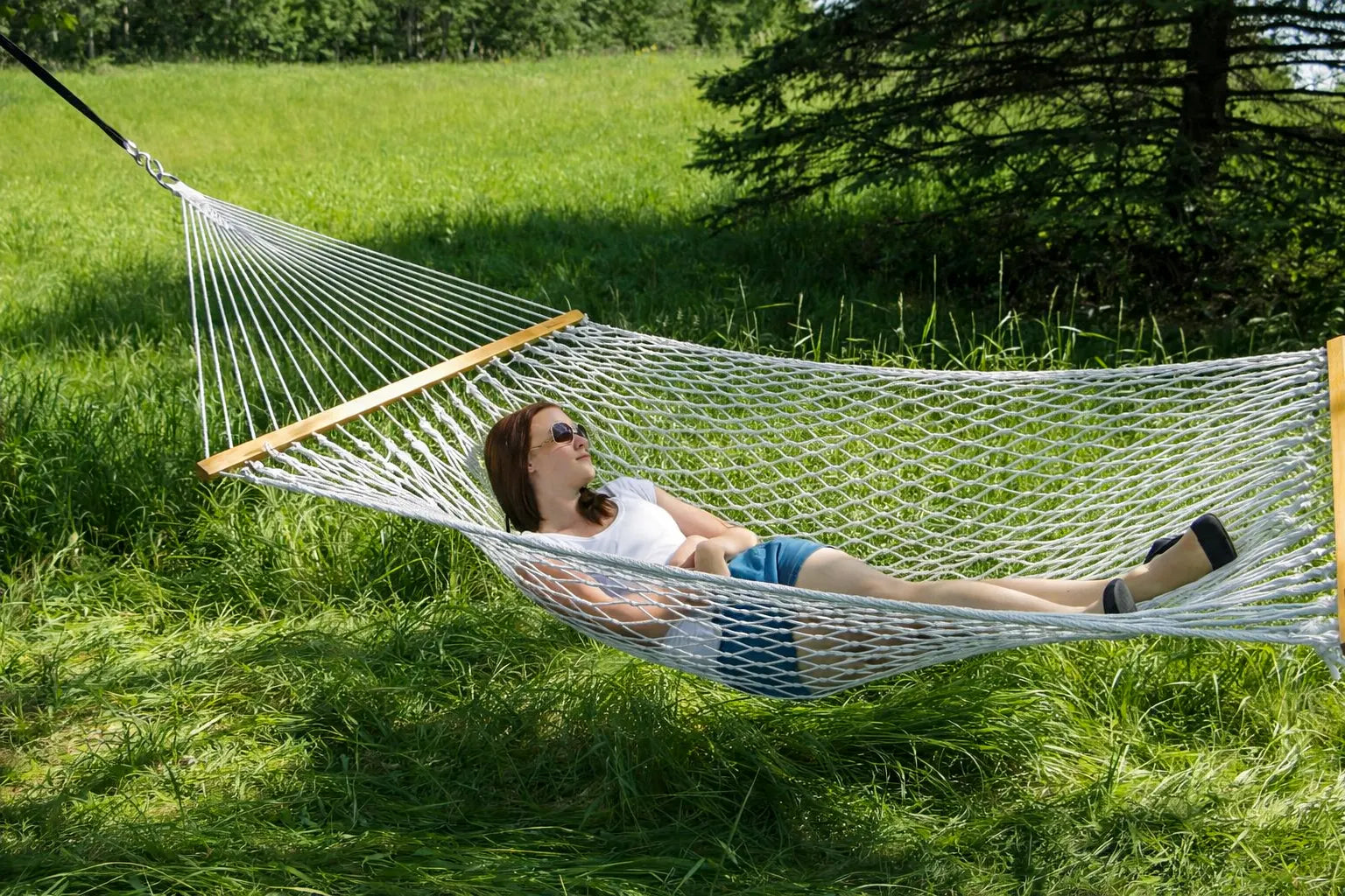 Person relaxing in a hammock in a grassy outdoor setting 50501-PWT