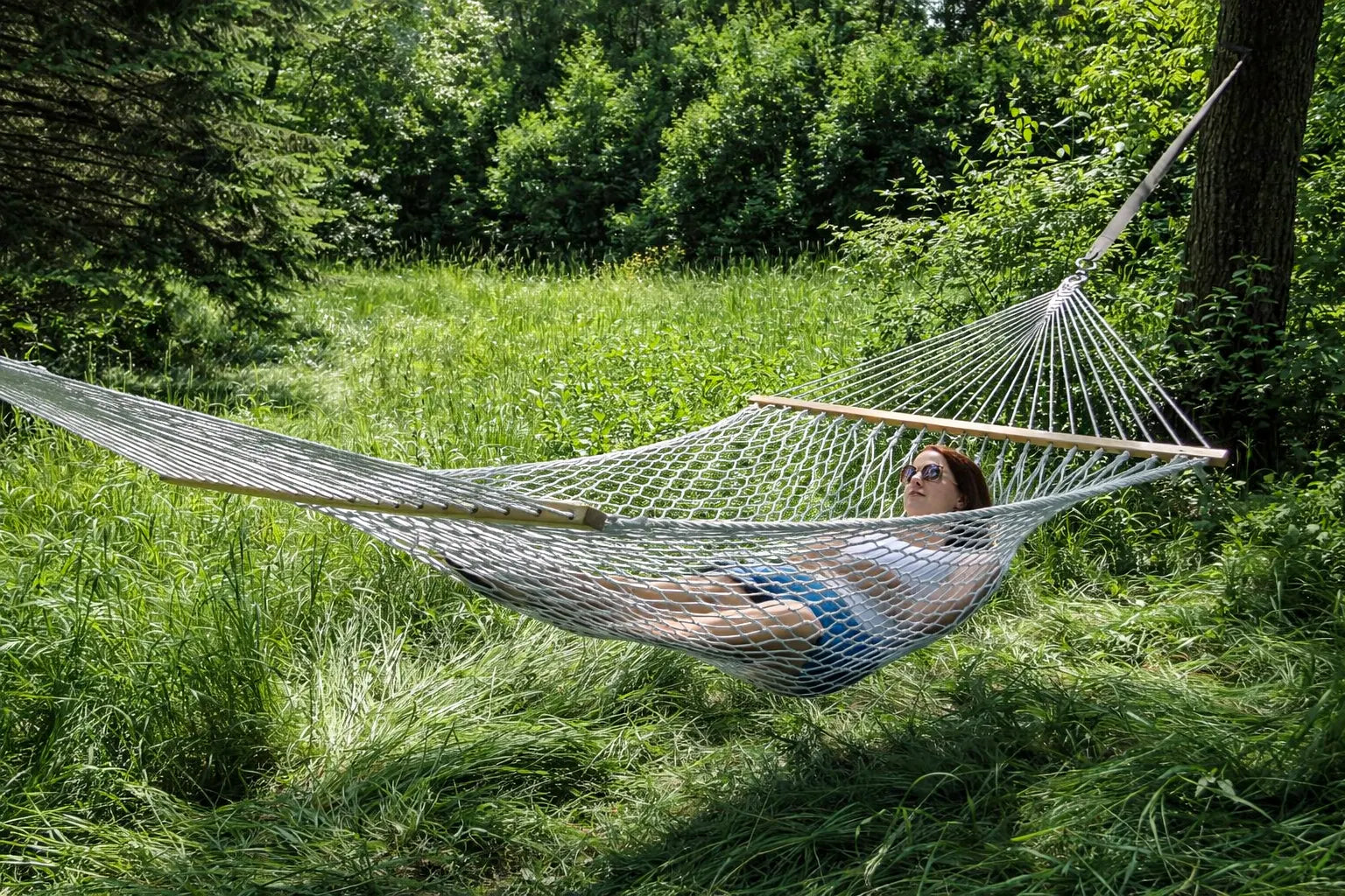 Person relaxing in a hammock surrounded by greenery 50501-PWT