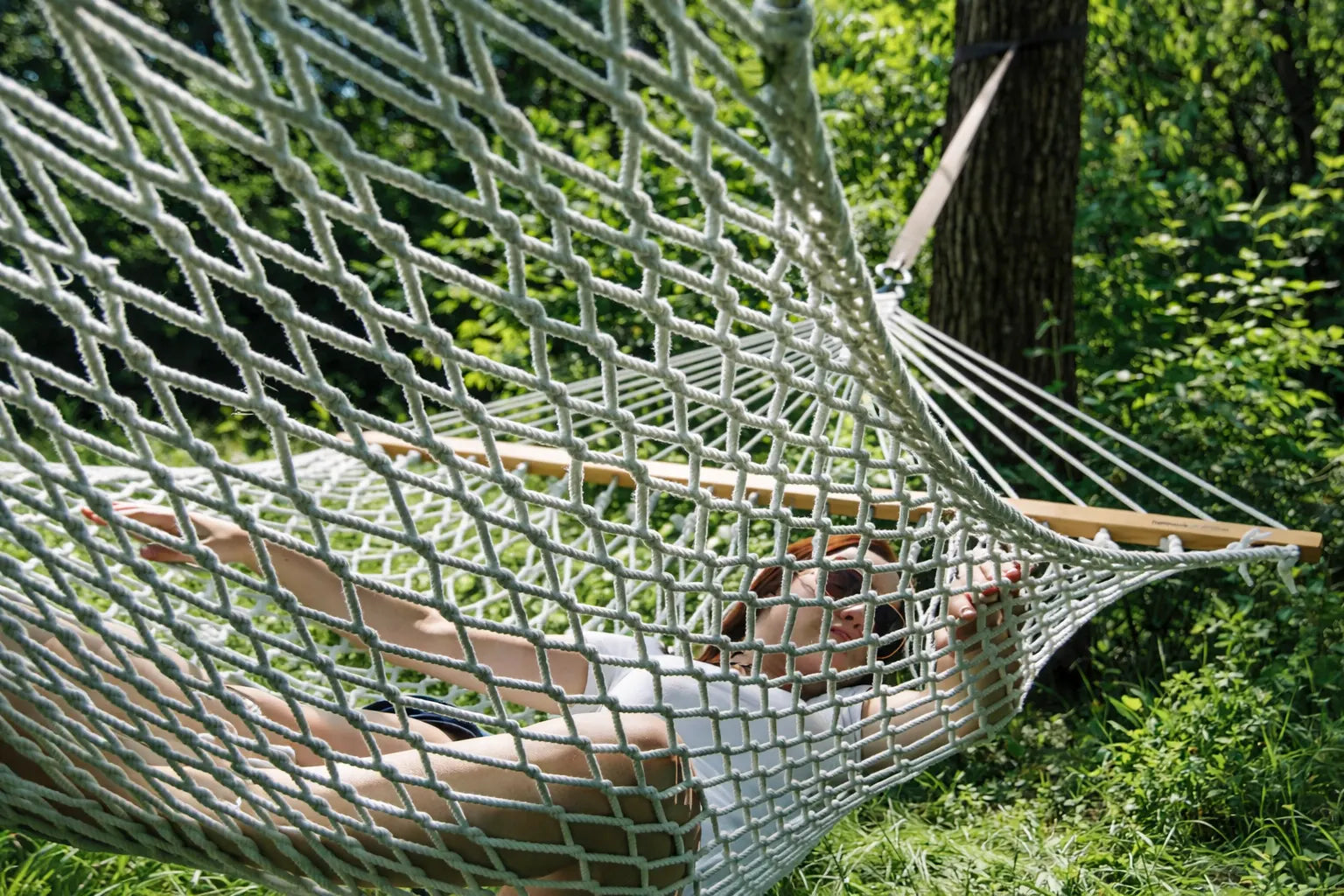 Person lying in a hammock surrounded by greenery  50501-PWT