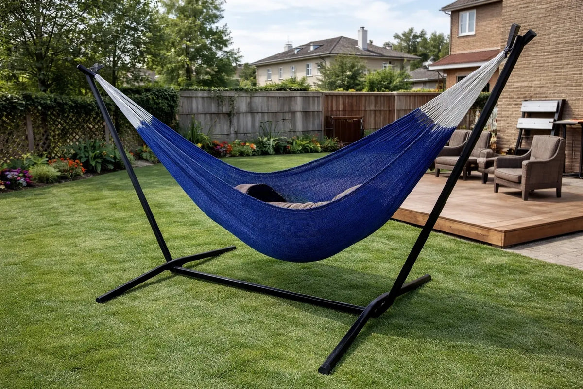 Blue hammock on a stand in a backyard setting