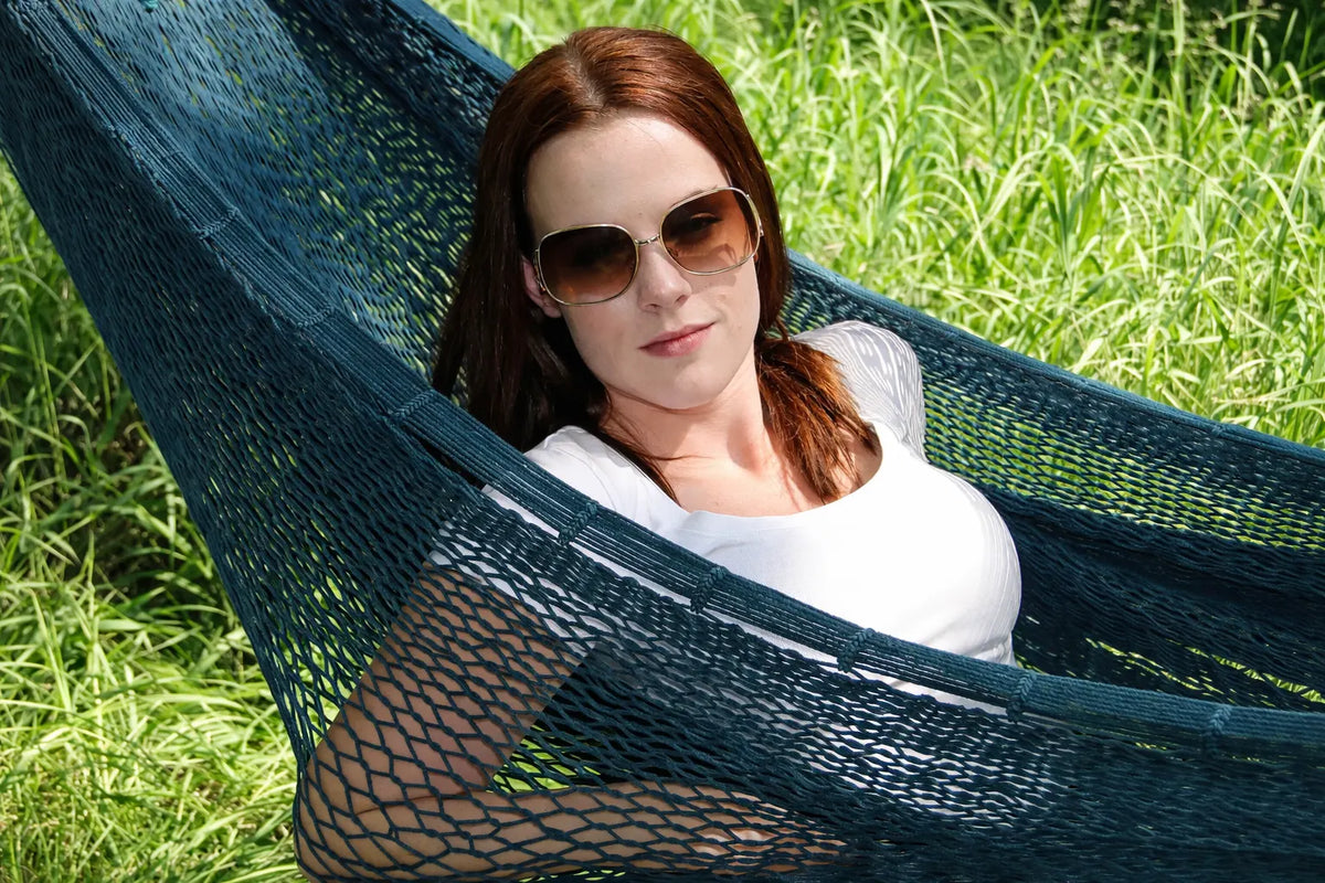 Woman relaxing in a green hammock on grass #24-MHXLTC-FG