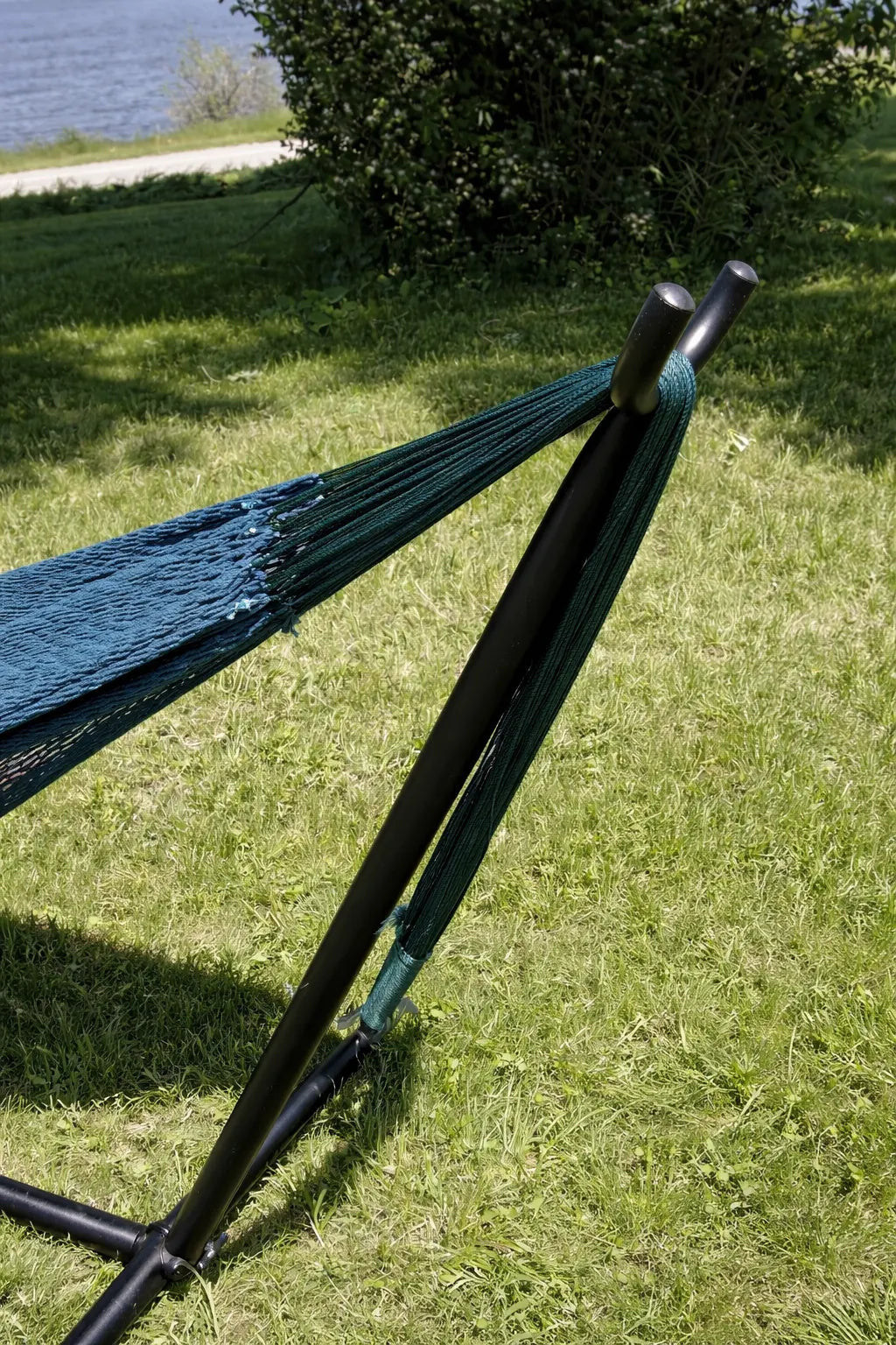 Blue hammock on a stand in a grassy area near a body of water #24-MHXLTC-FG+75121