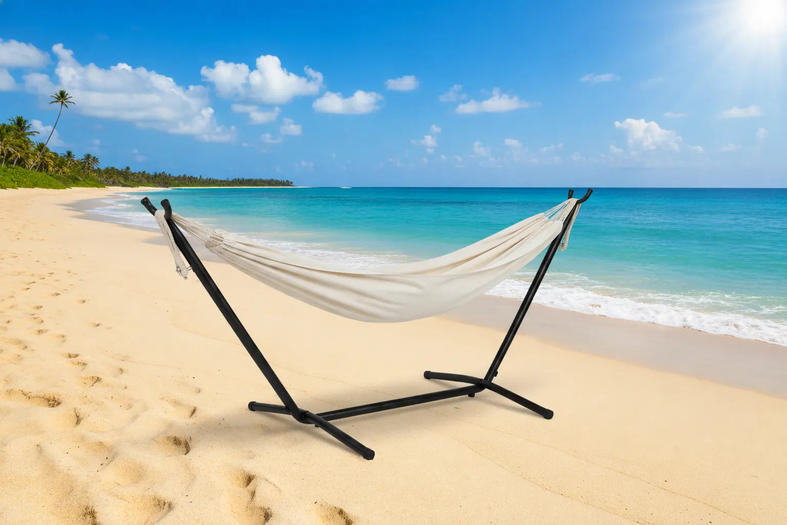Hammock on a stand on a sandy beach with ocean and sky in the background